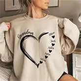 Beige sweatshirt featuring a black heart design with ’Grandma’ text and small hearts trailing off.